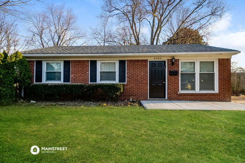 the front of a brick house with a black door