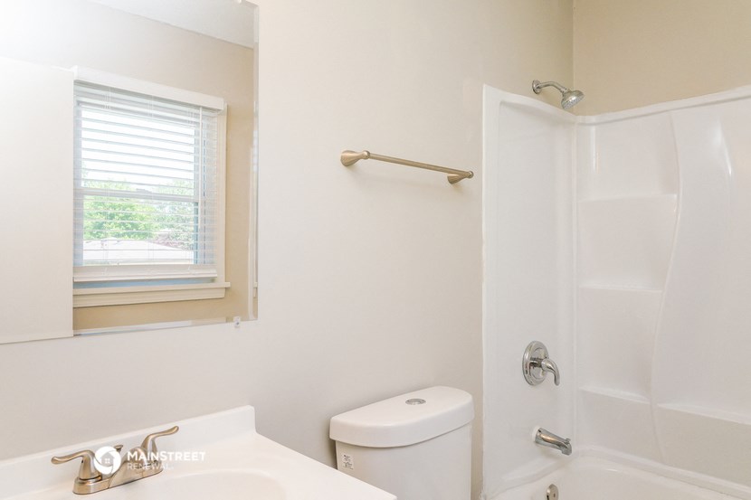 a bathroom with a toilet and a tub and a sink