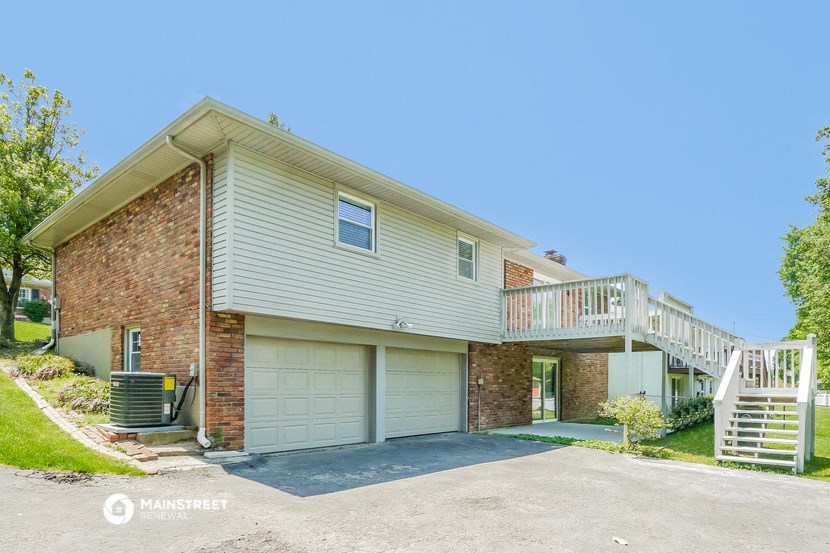 a white and brick house with a garage and a staircase