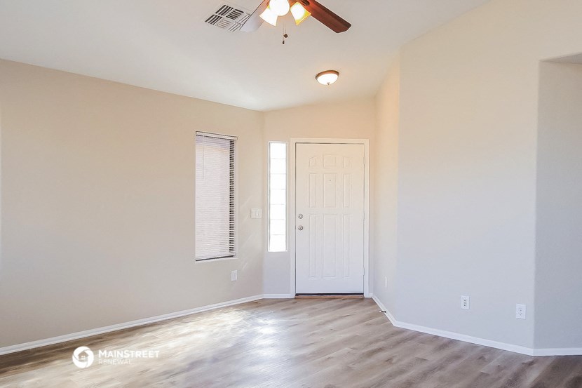 a empty room with a white door and a ceiling fan