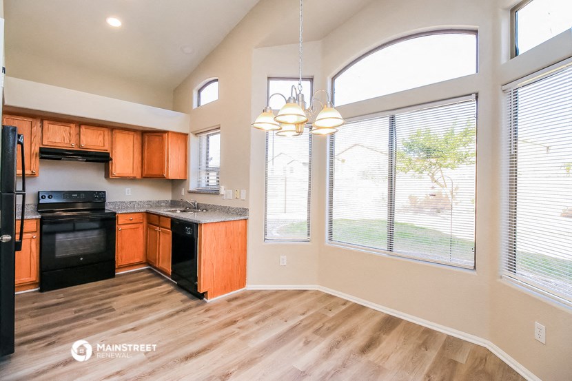 the kitchen and living room of an empty house with a large window