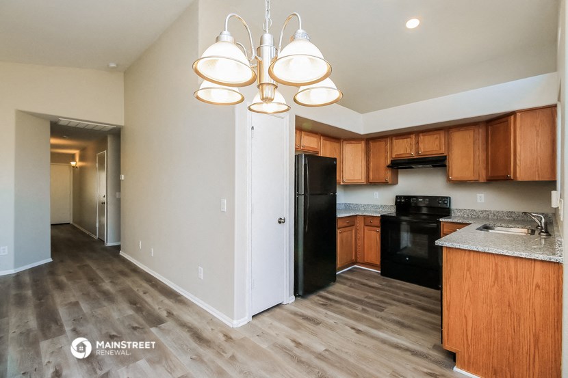a kitchen with wooden cabinets and a black refrigerator