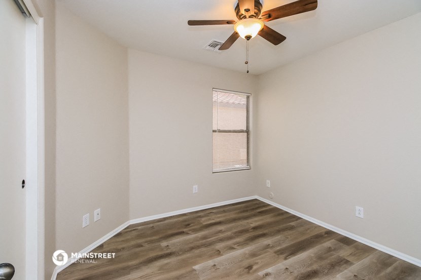 an empty room with a ceiling fan and a window