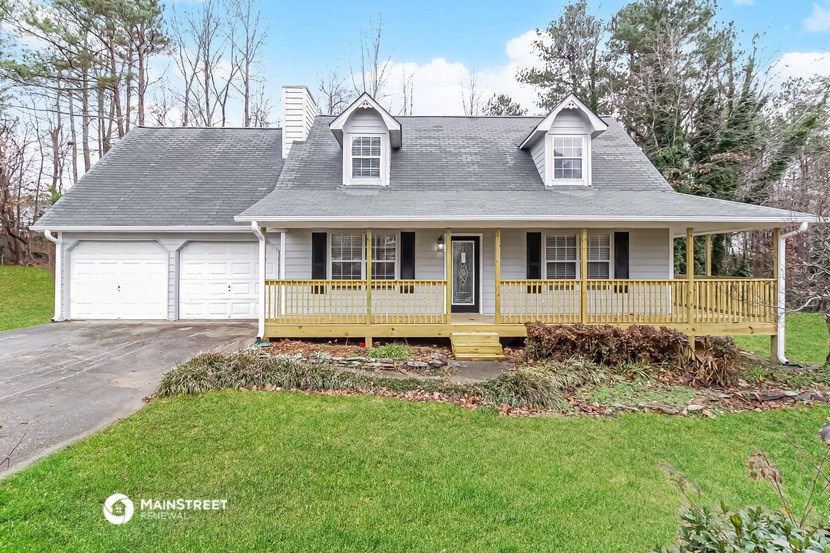a white house with a front porch and a garage