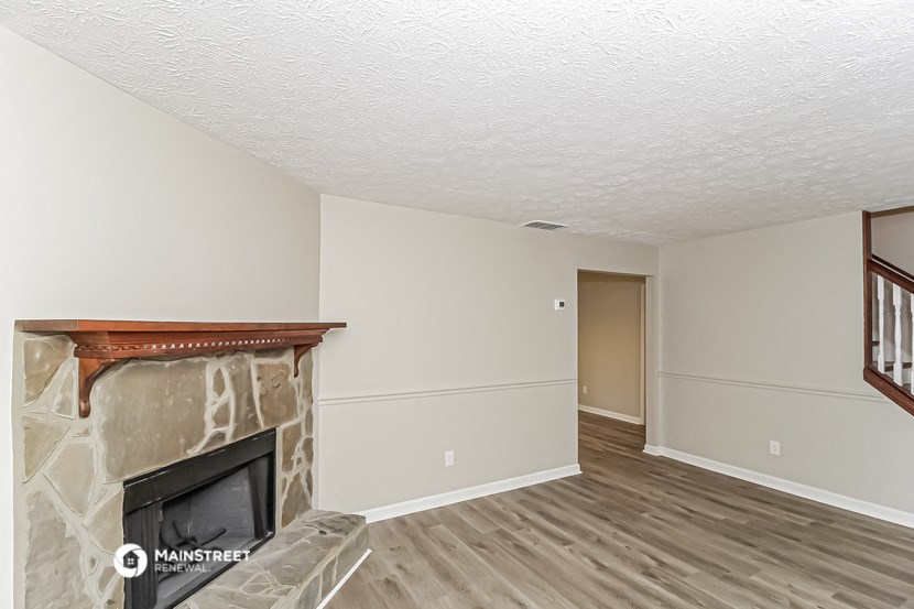 the living room of an empty house with a fireplace