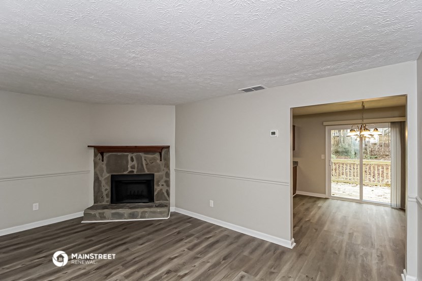 the living room of an empty house with a fireplace