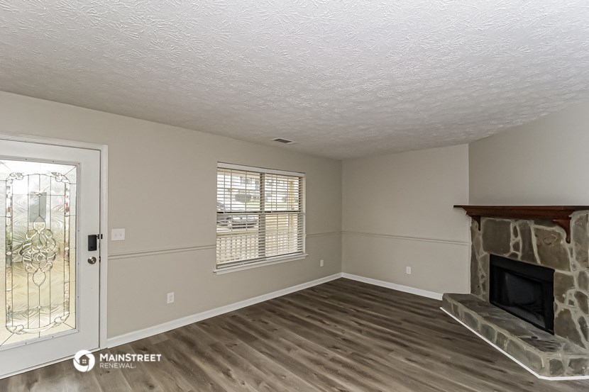 the living room of an empty house with a fireplace