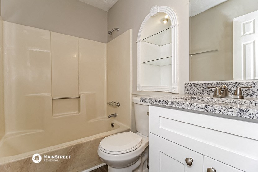 a bathroom with a toilet and a tub and a sink