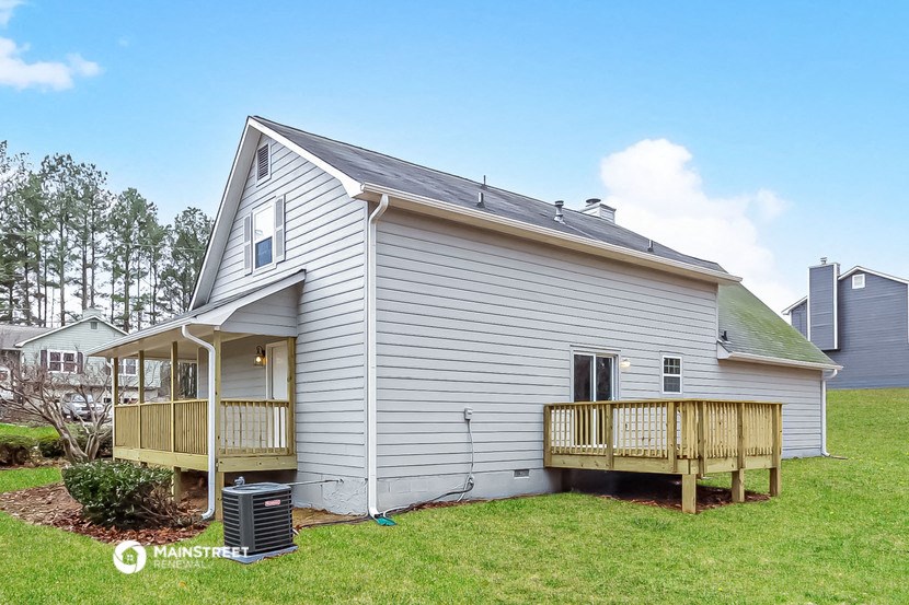 a small white house with a porch and a garage