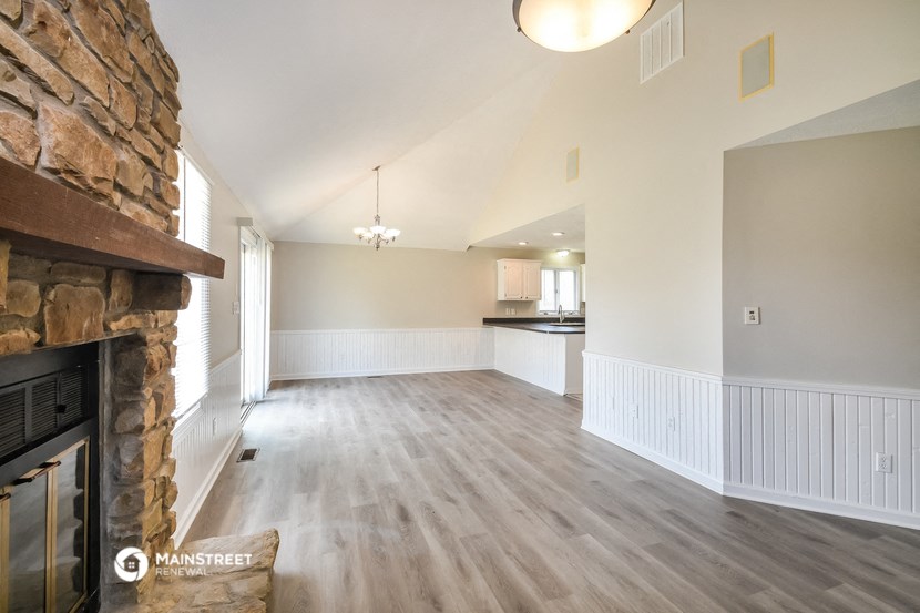 the living room and kitchen of a new home with a stone fireplace