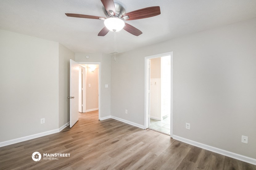 an empty living room with a ceiling fan