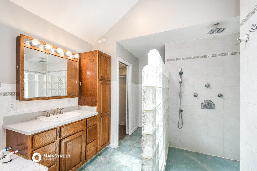 a bathroom with a shower and a sink and a mirror
