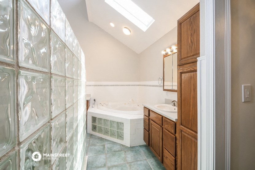 a bathroom with a tub and a shower and a sink