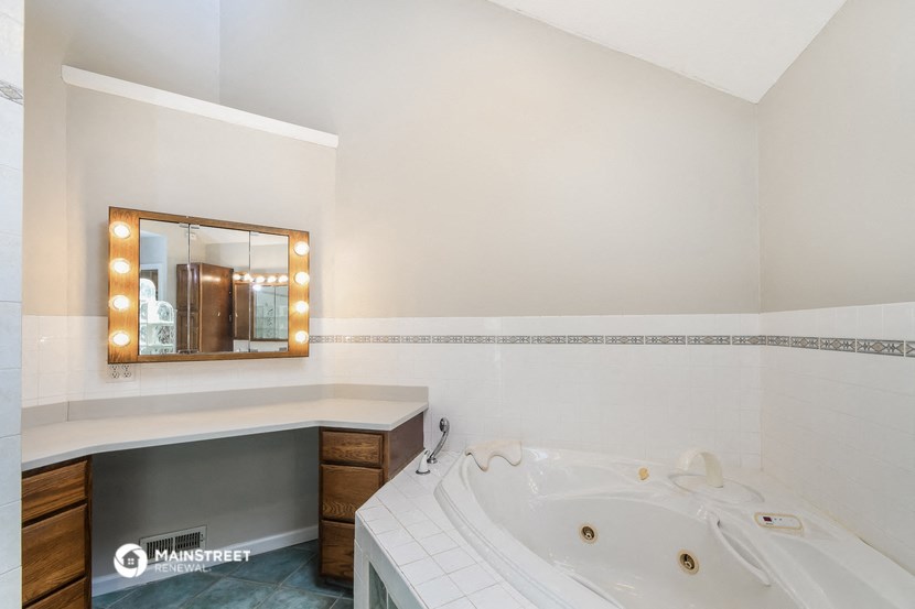 a bathroom with a jacuzzi tub and a mirror