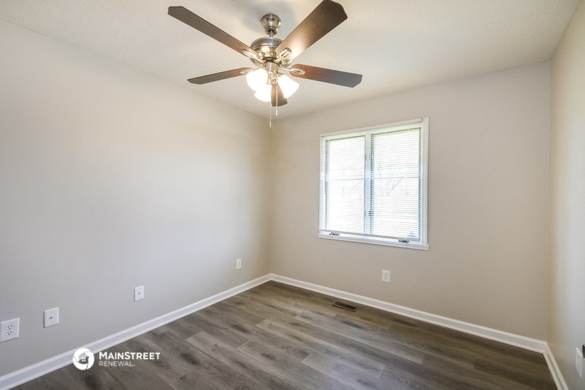 a bedroom with a ceiling fan and a window