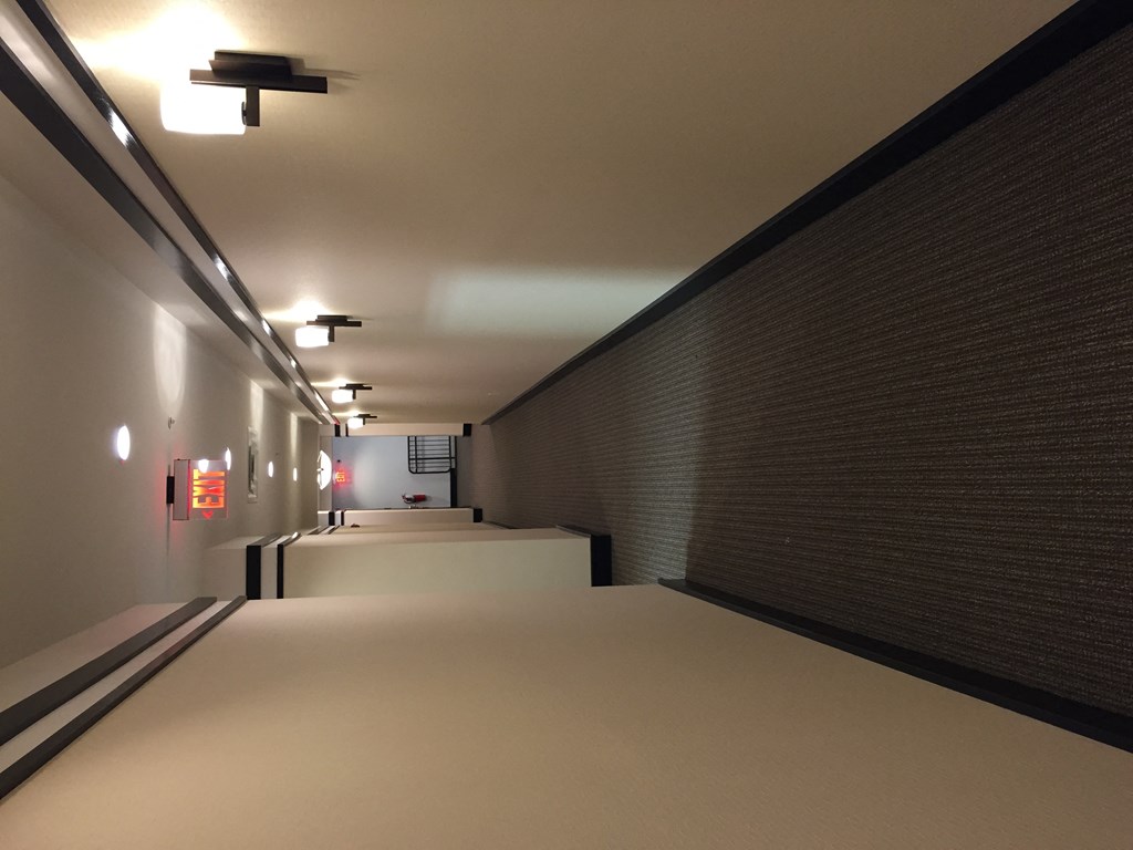 a long hallway with a white floor and a brick wall