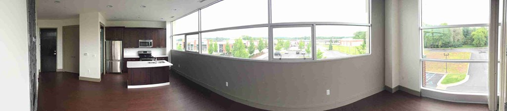 an empty room with a curved wall and large windows