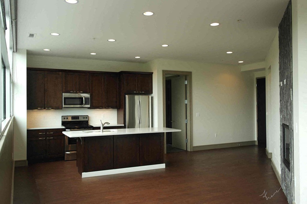 an empty kitchen with a sink and a refrigerator