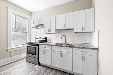 a kitchen with white cabinets and stainless steel appliances