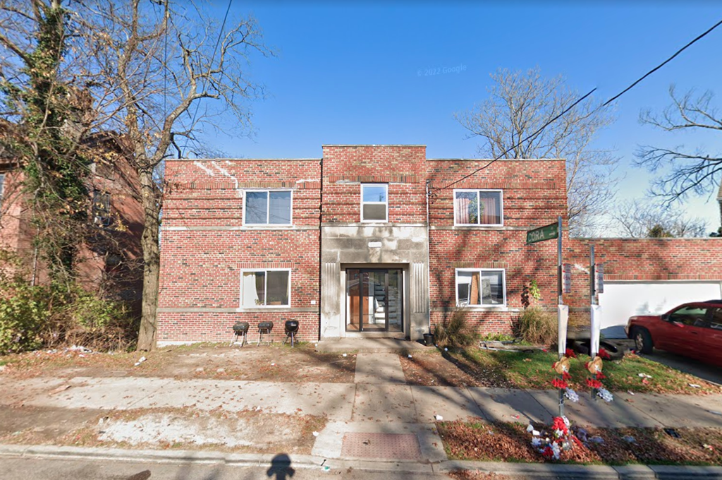 A red brick house with a white door and windows.