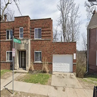 A brick building with a white garage door in front.