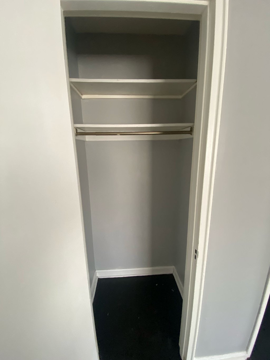 A white open cupboard with three shelves.