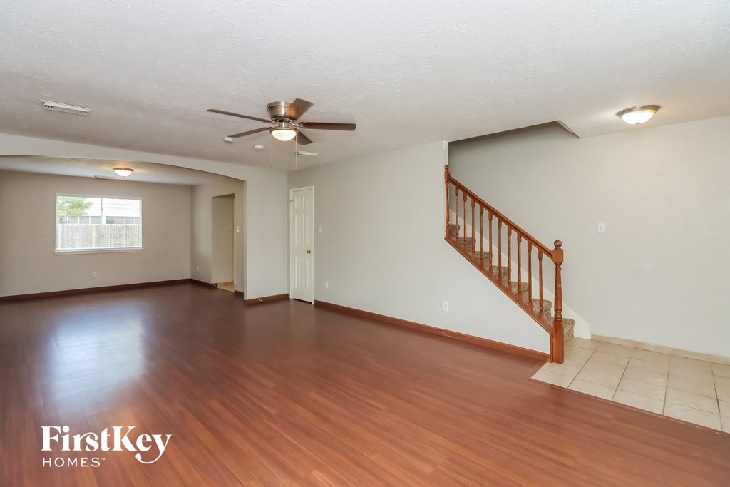 the living room and dining room with hardwood flooring and a ceiling fan