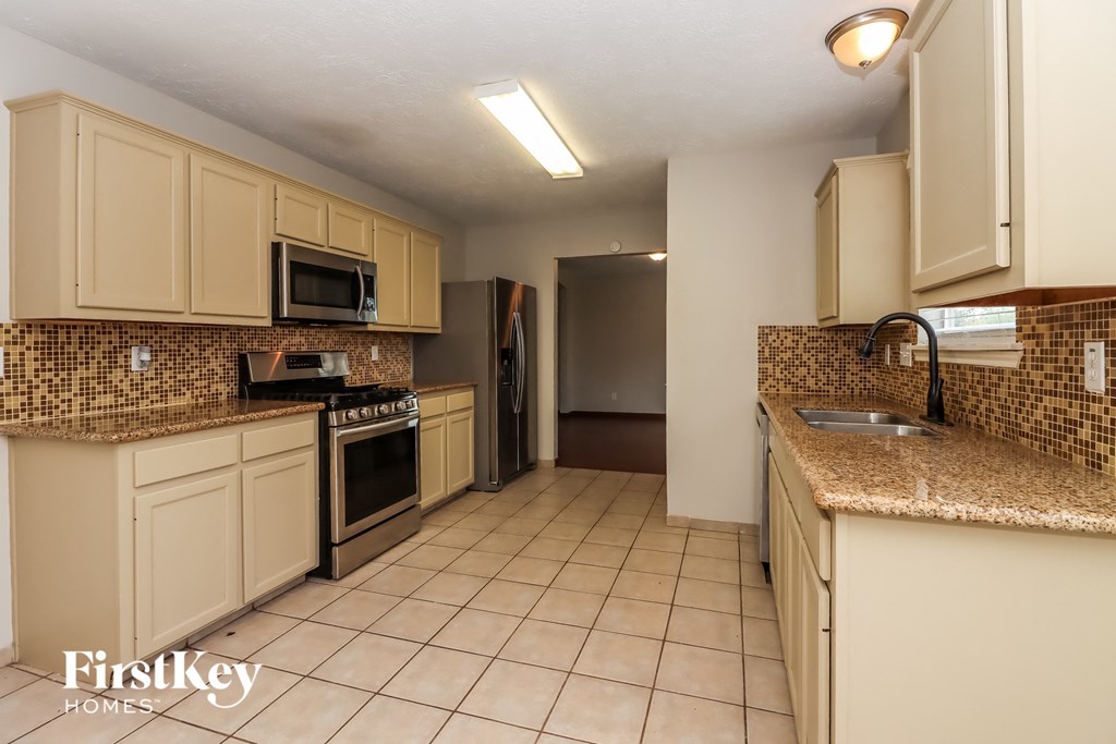 a kitchen with white cabinets and granite counter tops