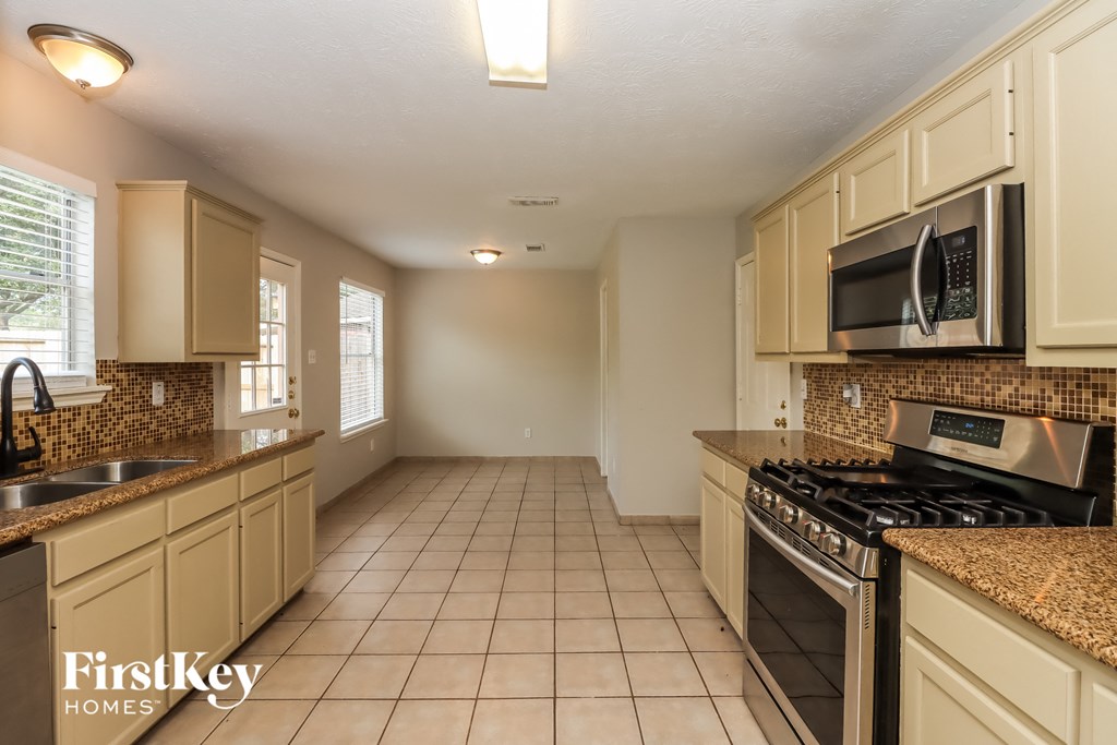 a kitchen with a stove and a sink and a microwave