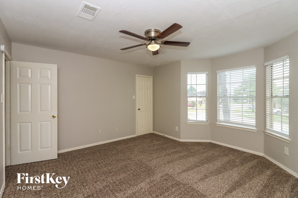 the living room of an empty house with a ceiling fan