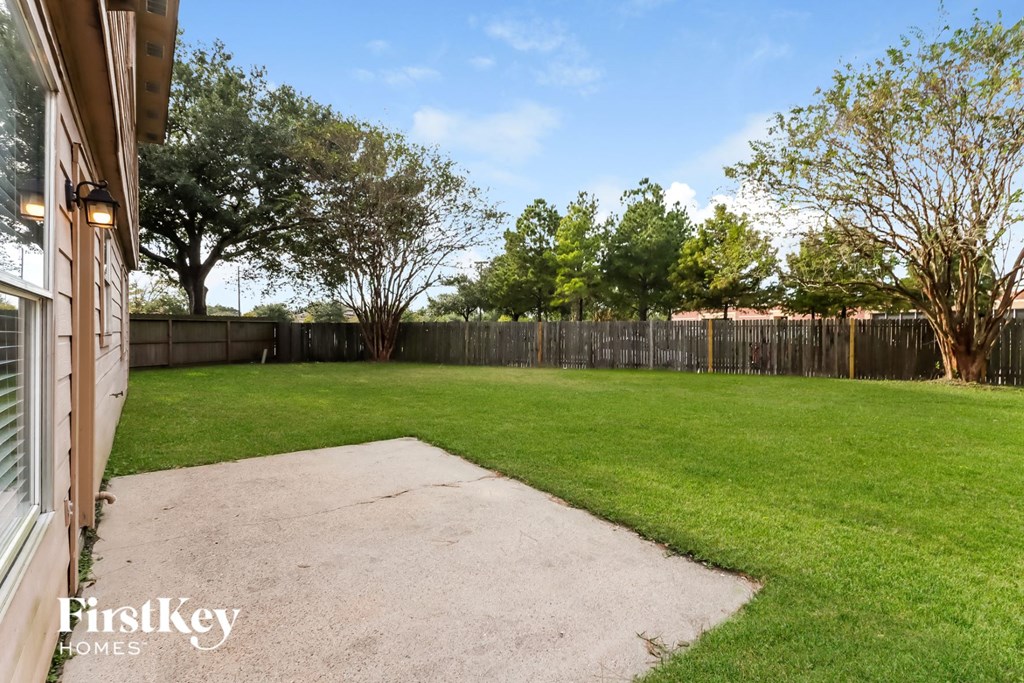 the backyard of a house with a lawn and a fence