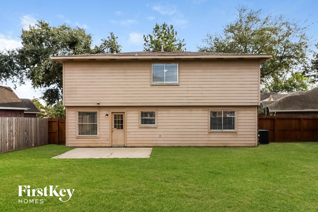 a wooden house with a yard and a wooden fence