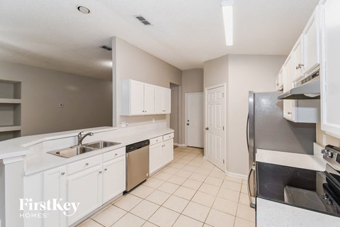 A kitchen with white cabinets and a stainless steel dishwasher.