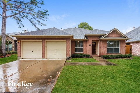 A brick house with a garage door is for sale.