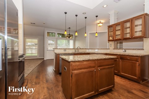 A modern kitchen with wooden cabinets and a marble countertop.