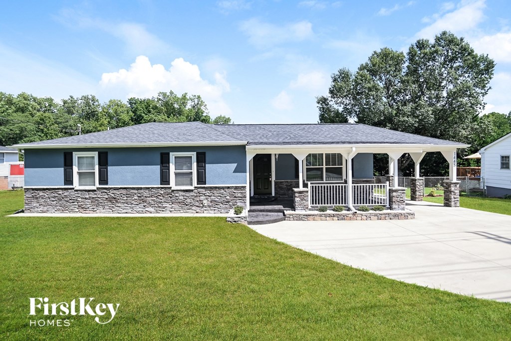 a blue and white house with a porch and a lawn