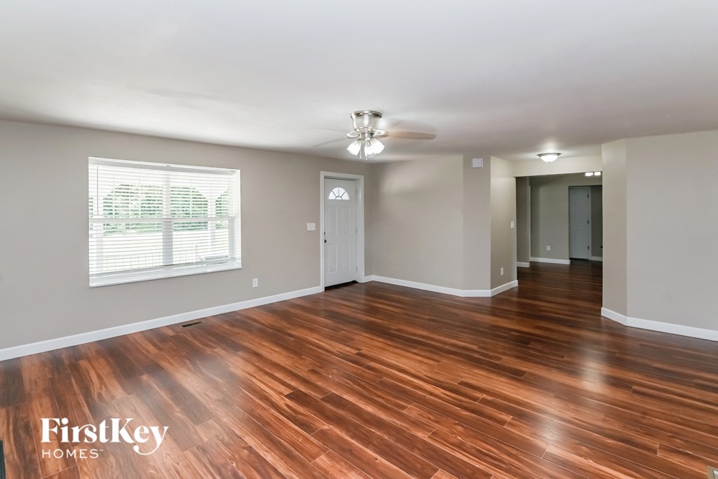 a living room with a hard wood floor and a ceiling fan
