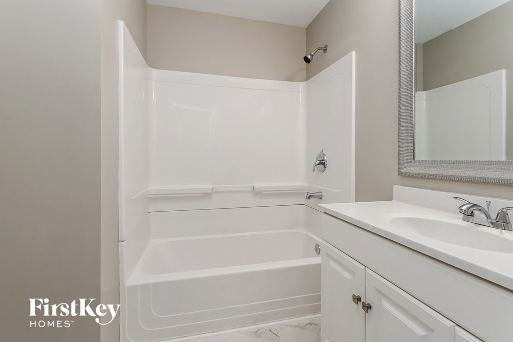 a bathroom with a tub and a sink and a mirror