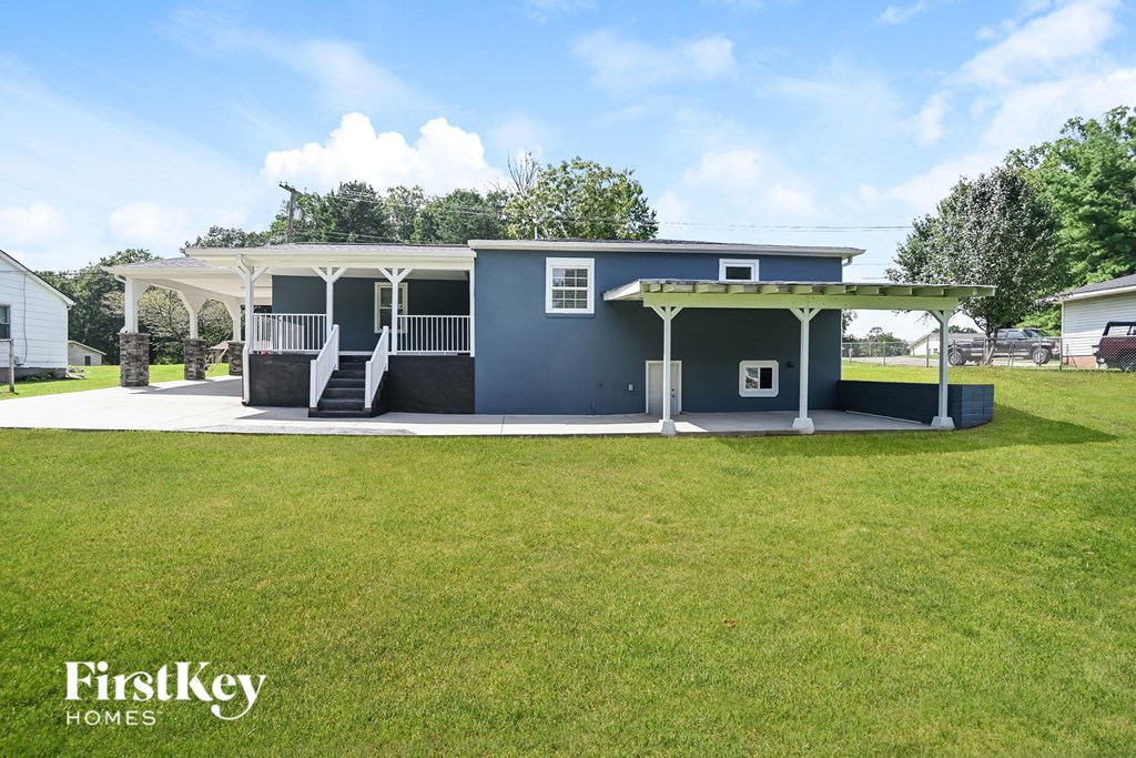 a blue house with a porch and a grassy yard