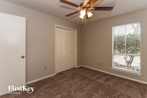 a bedroom with a ceiling fan and a window