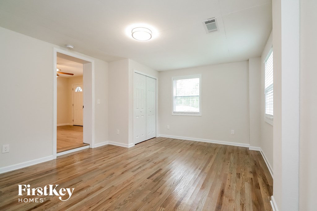 the living room and dining room with wood flooring and white walls