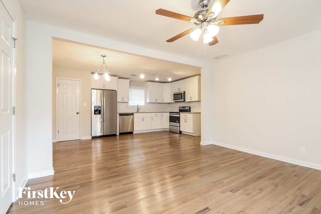 a living room and kitchen with a ceiling fan and wood floors