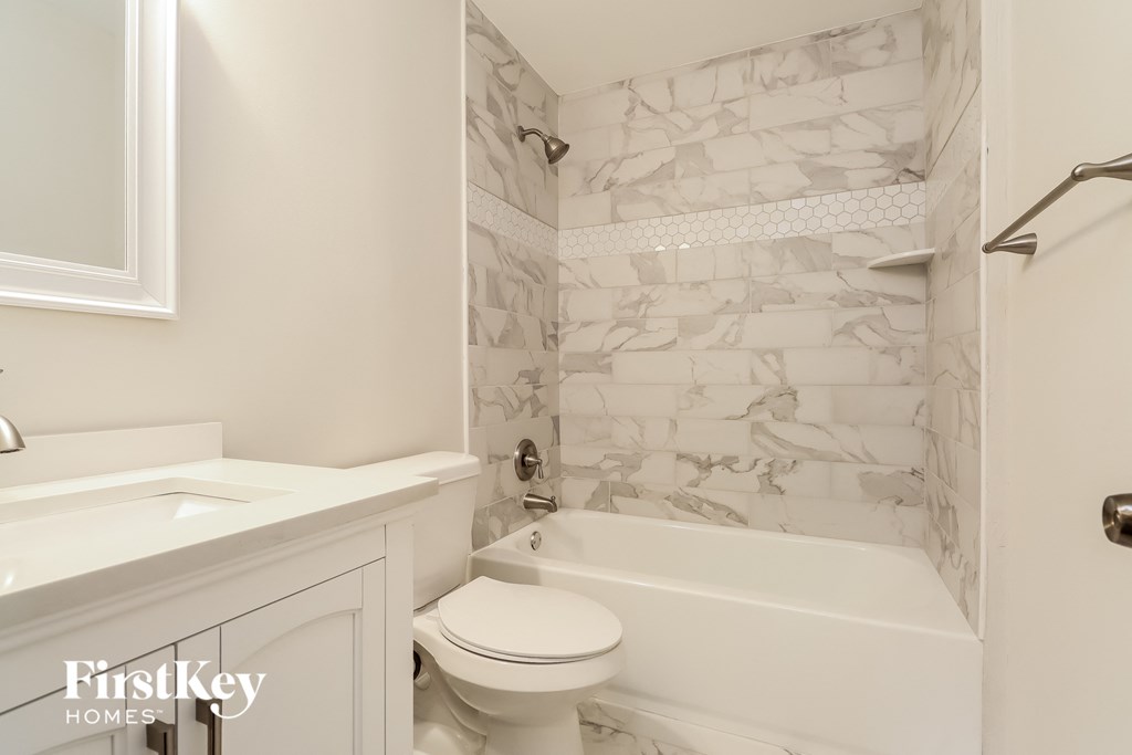 a bathroom with a toilet and a tub and a sink