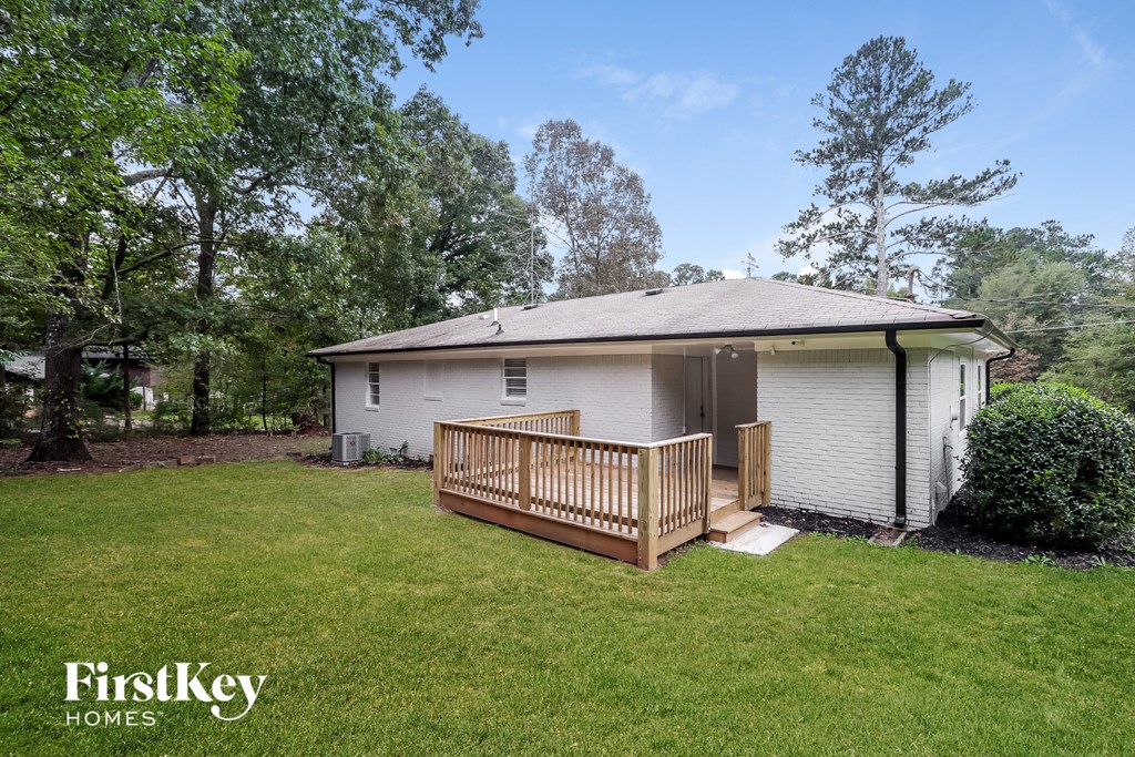 a small white house with a deck and a yard
