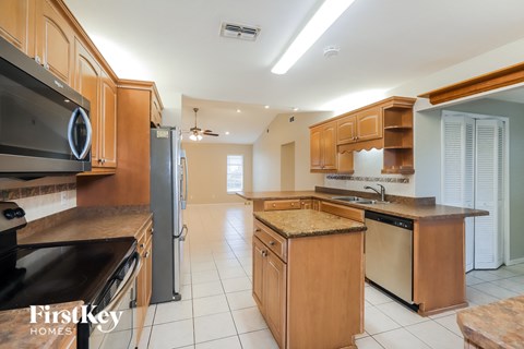 a large kitchen with stainless steel appliances and wooden cabinets