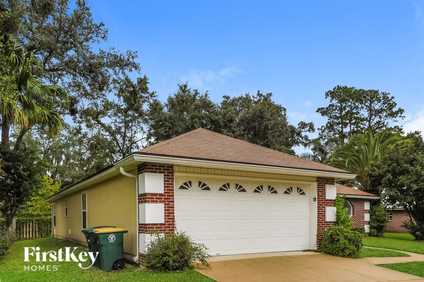 A house with a brown roof and a white garage door is shown.