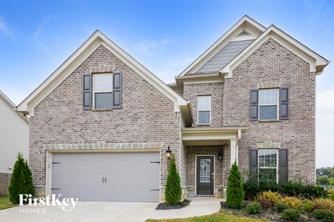 a brick house with a garage door on a driveway