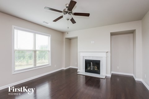 a living room with a fireplace and a ceiling fan
