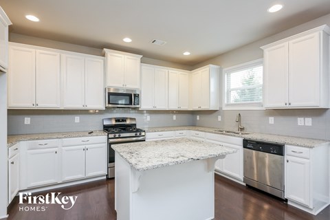 a white kitchen with white cabinets and a counter top