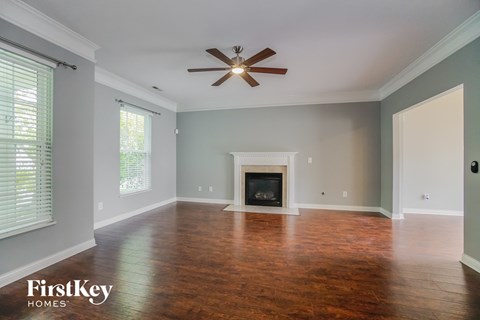 a living room with a fireplace and a ceiling fan